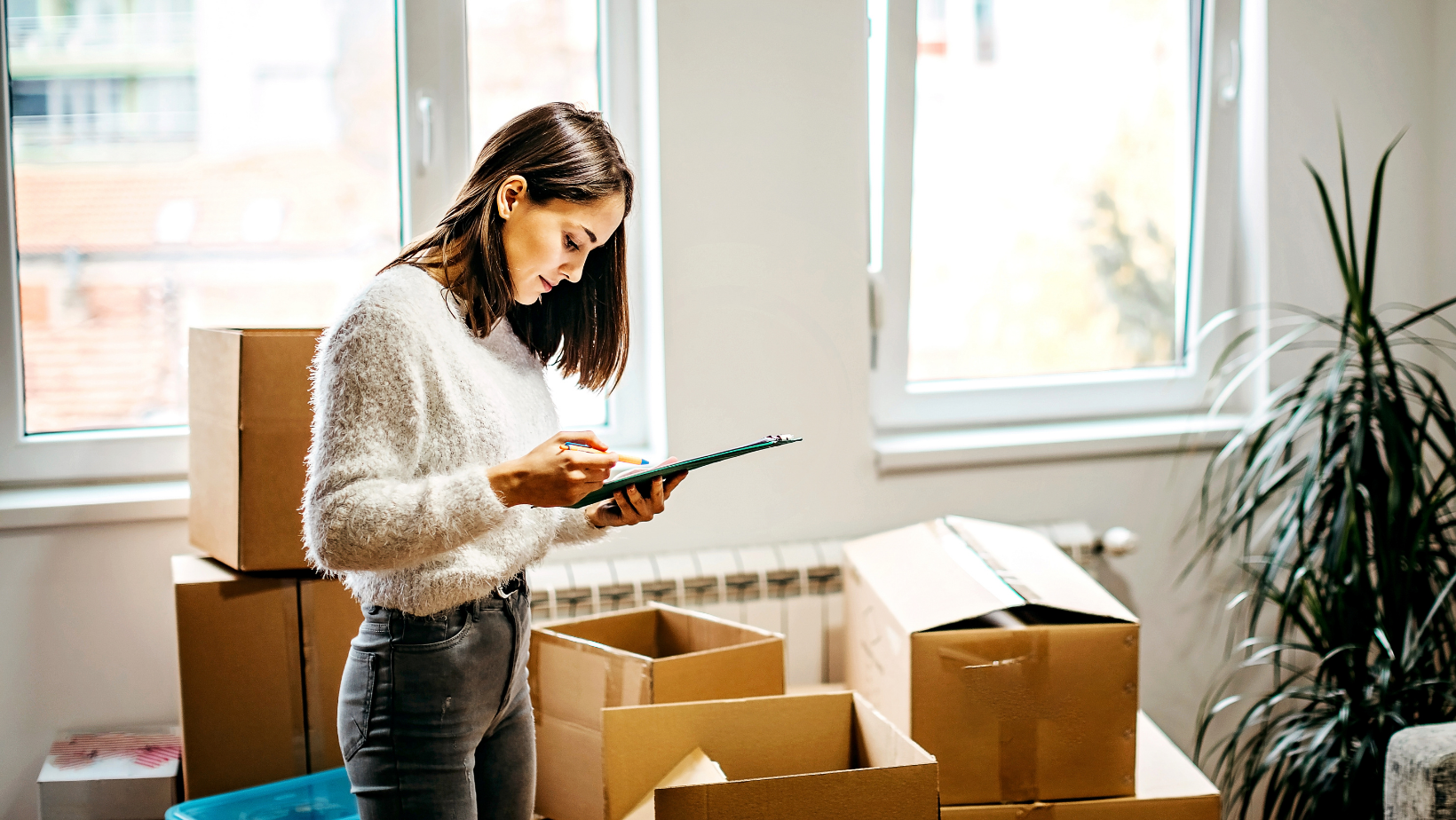 woman holding a clipboard and looking and moving checklist