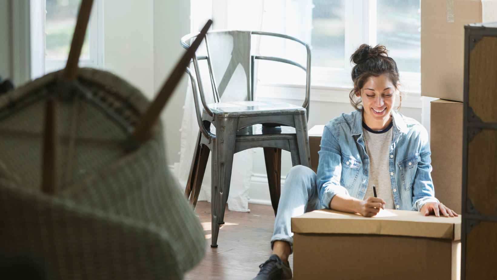 woman sitting while writing on checklist on box